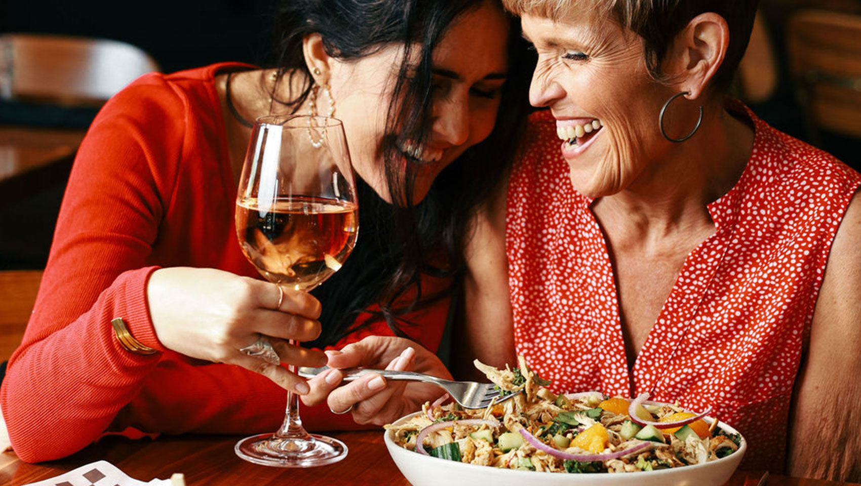 Friends laughing while enjoying dinner at The Good Sport