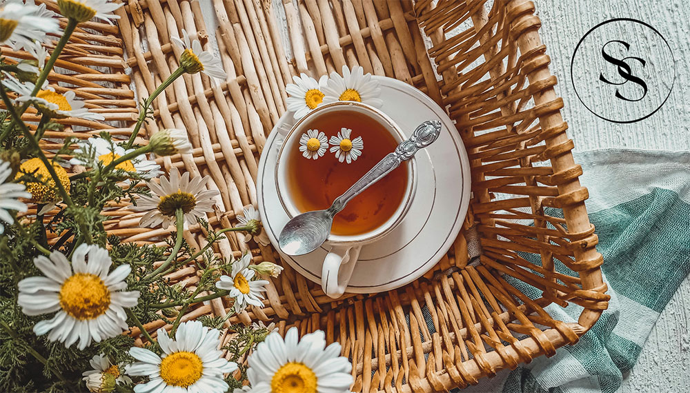 cup of tea in basket with flowers